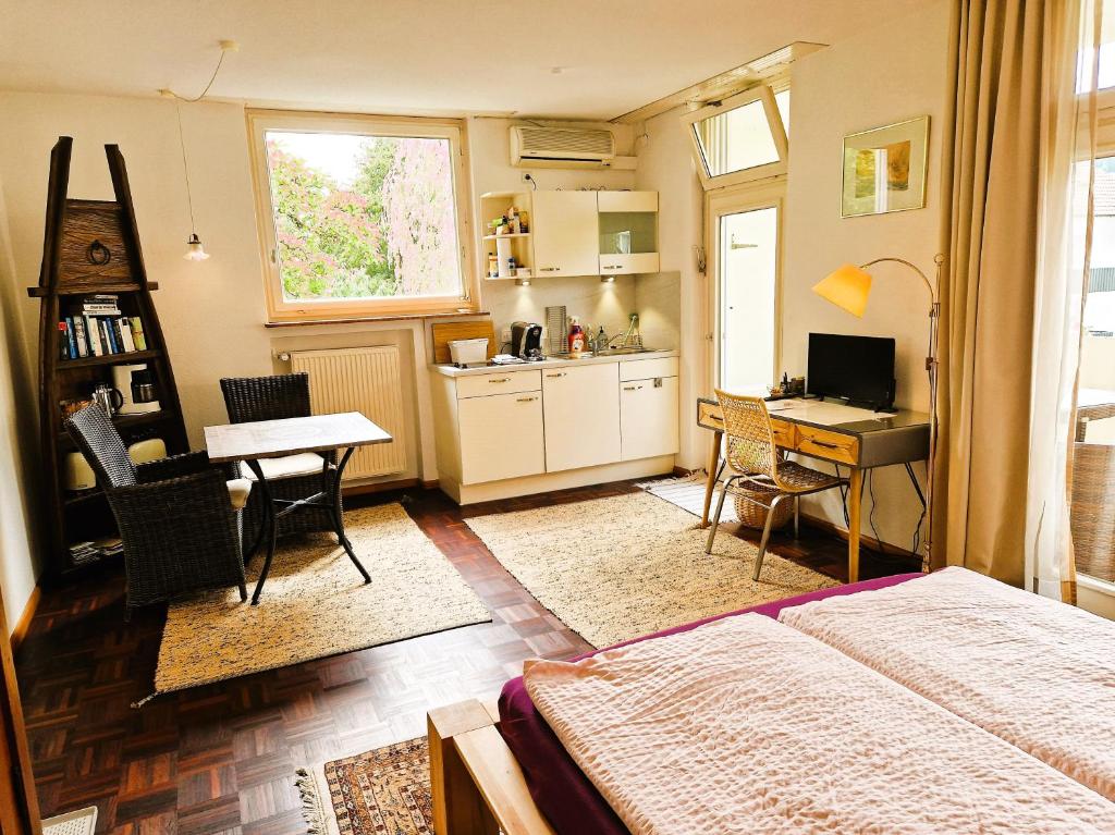 ein Schlafzimmer mit einem Bett und einem Schreibtisch sowie eine Küche in der Unterkunft Freiburg citynah - hell, ruhig, gemütlich in Freiburg im Breisgau