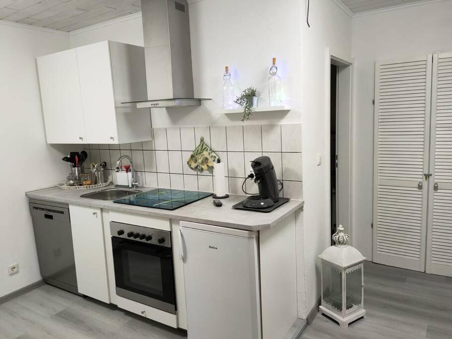 een keuken met witte kasten en een aanrecht bij Gemütliche Einliegerwohnung im Fachwerkhaus in Bröckel