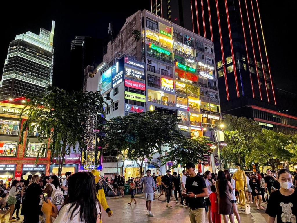 a crowd of people walking down a city street at night at 4K Hostel in Ho Chi Minh City