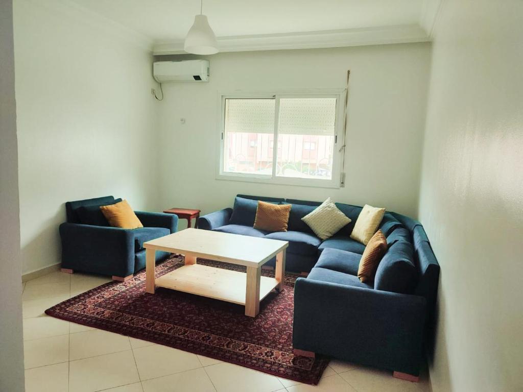 a living room with a blue couch and a table at SkyRise 1 Khemisset 2 bedrooms in Khemisset