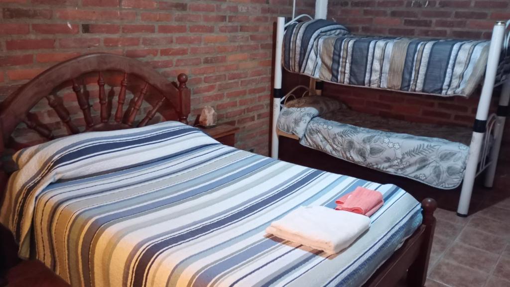 1 dormitorio con cama y pared de ladrillo en Los abuelos en Puerto Madryn