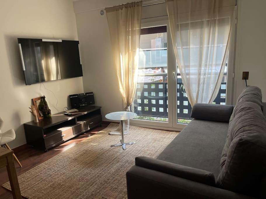 a living room with a couch and a large window at Ski y Montaña Encamp in Encamp