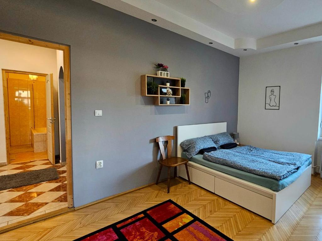 een slaapkamer met een bed met een blauw dekbed bij Lovely central apartment with free parking, Központhoz közeli 3 szobás lakás in Győr