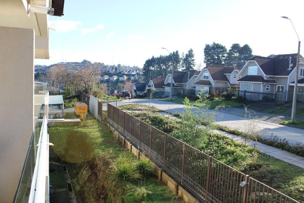 a view of a street with houses and a fence at TuarriendoCL-MPHC304 Cómodo Departamento Puerto Varas in Puerto Varas