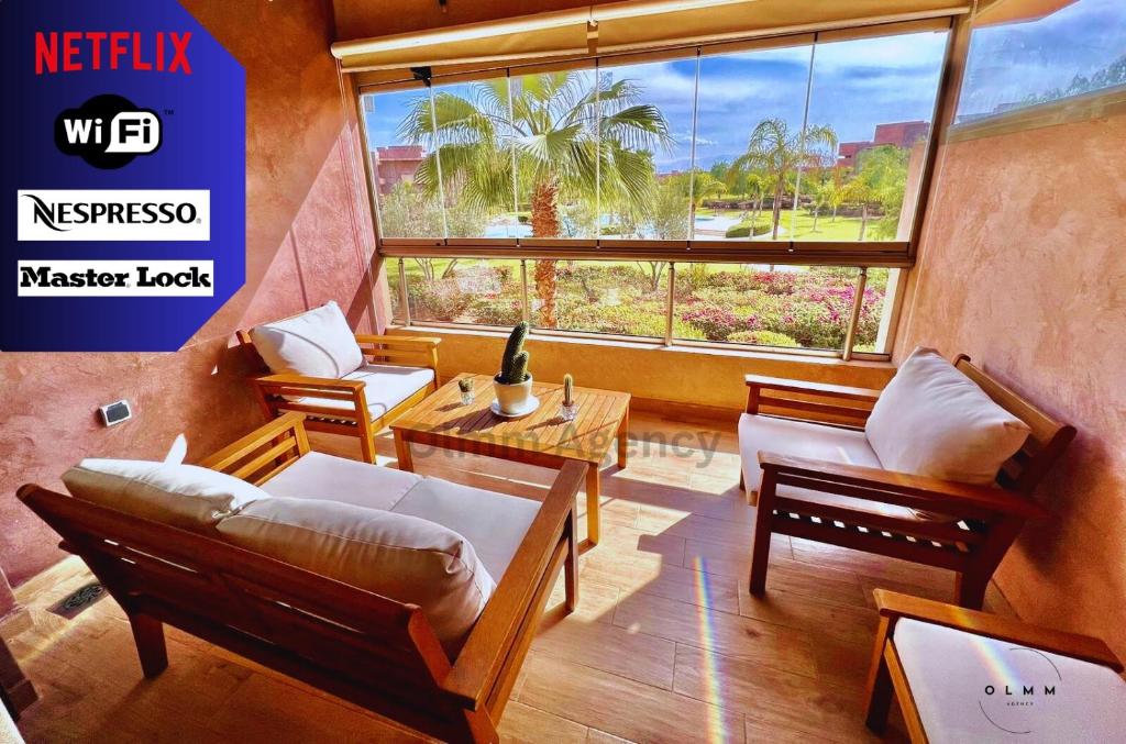 - un salon avec une grande fenêtre et un canapé dans l'établissement Luxurious Stay at Prestigia Golf Marrakech with Golf Course, Pool, and Breathtaking Atlas Mountains View, à Marrakech