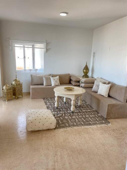 a living room with a couch and a table at Dar Yasmina in Sidi Ifni
