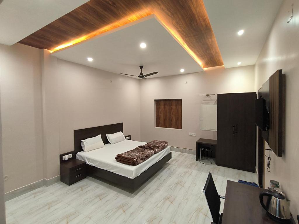 Mandakini Homestay في فاراناسي: غرفة نوم فيها سرير وتلفزيون