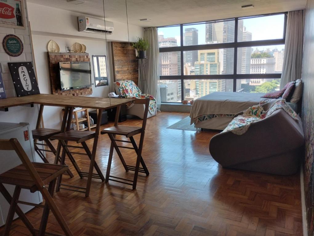 a bedroom with a bed and a table and chairs at Mirante do Vale - Centro Histórico de São Paulo in Sao Paulo