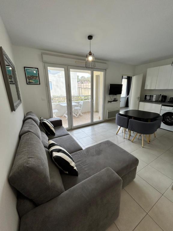 uma sala de estar com um sofá e uma mesa em Appartement avec Terrasse et box em Marselha