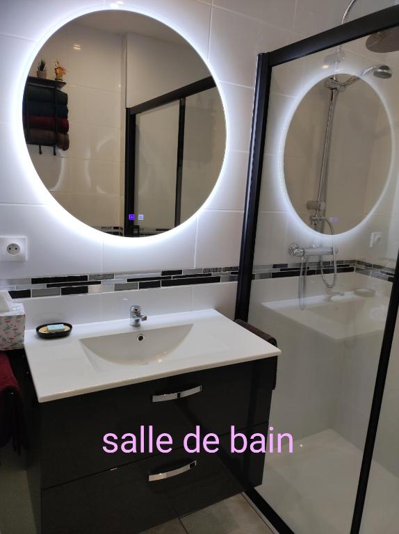 une salle de bain avec un lavabo et un miroir dans l'établissement John & Ghislaine, à Donjeux