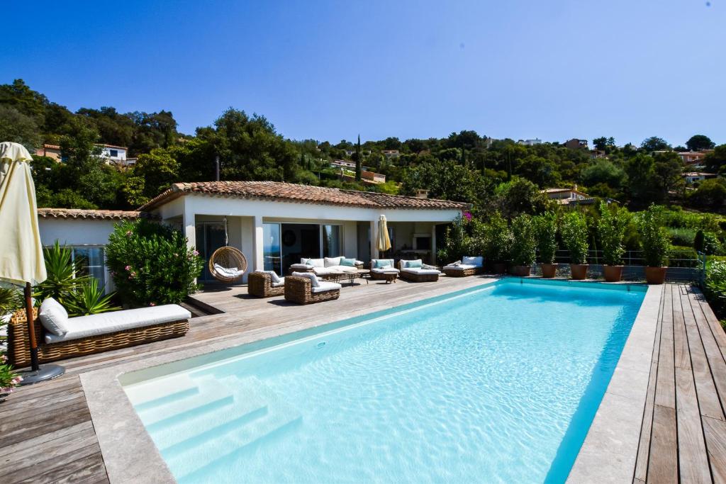 een villa met een zwembad en een huis bij Villa Les Agrumes vue panoramique sur mer in La Croix-Valmer