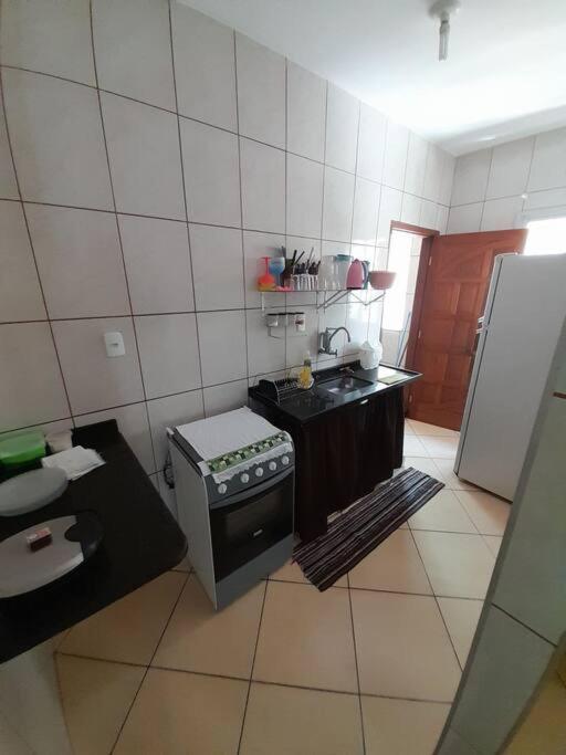 uma pequena cozinha com um fogão e um frigorífico em Excelente Localização em Jacaraípe em Serra