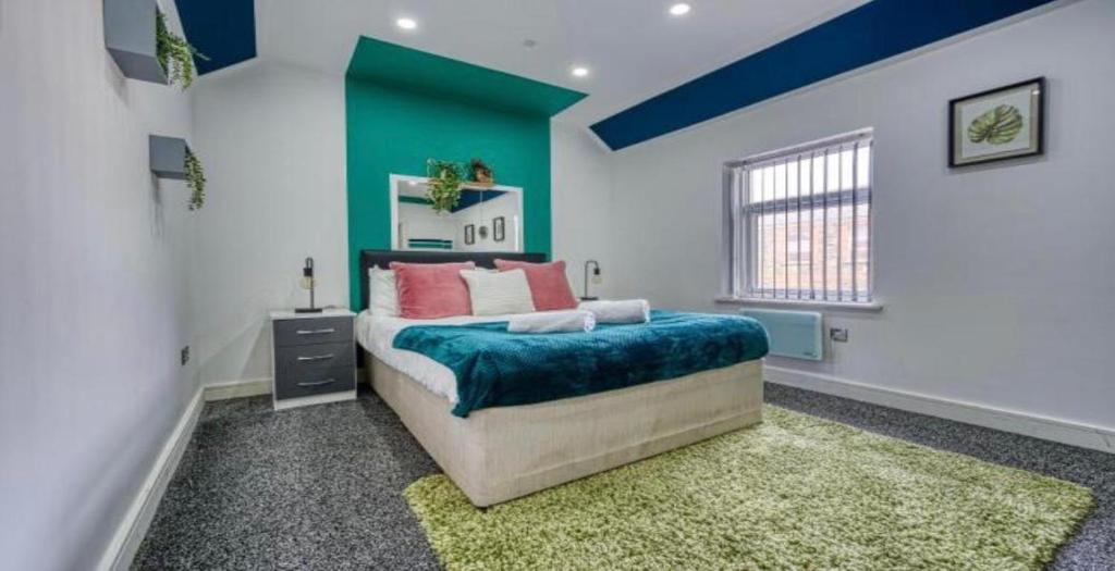 a bedroom with a bed with a blue accent wall at Modern Flat near City Centre - 8 Guests, 2 Baths in Cardiff
