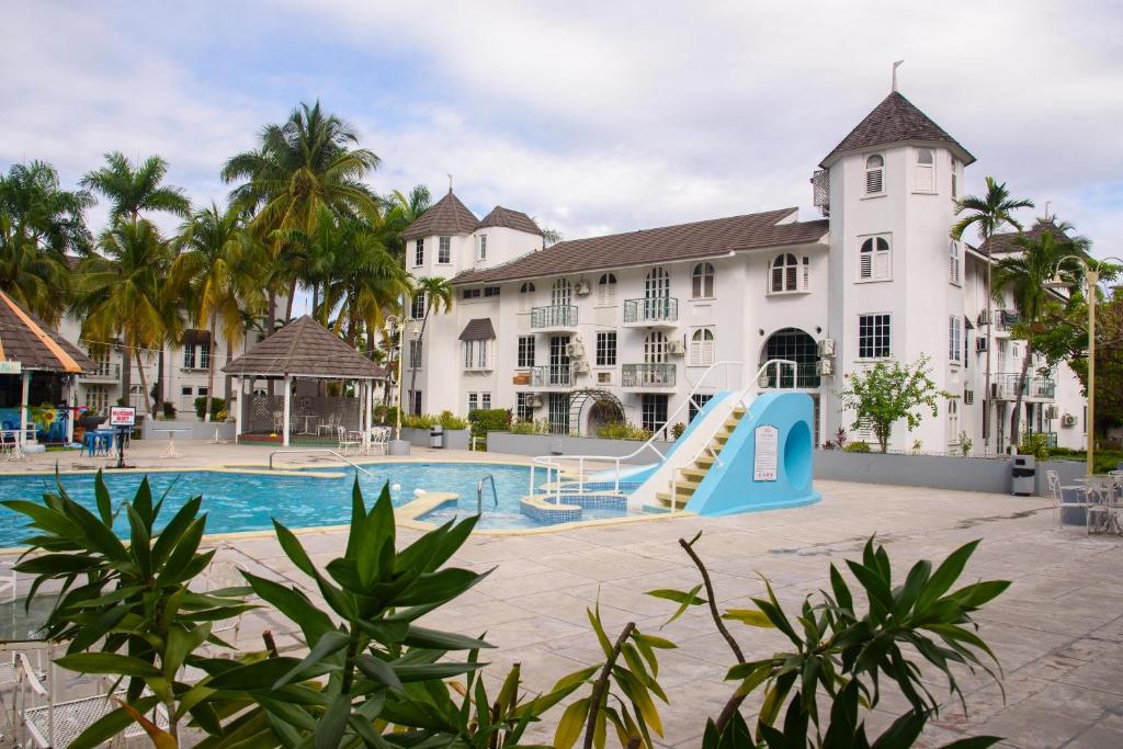 a resort with a pool and a slide at Czar's Oasis Apt B27 @ Ocho Rios in Ocho Rios