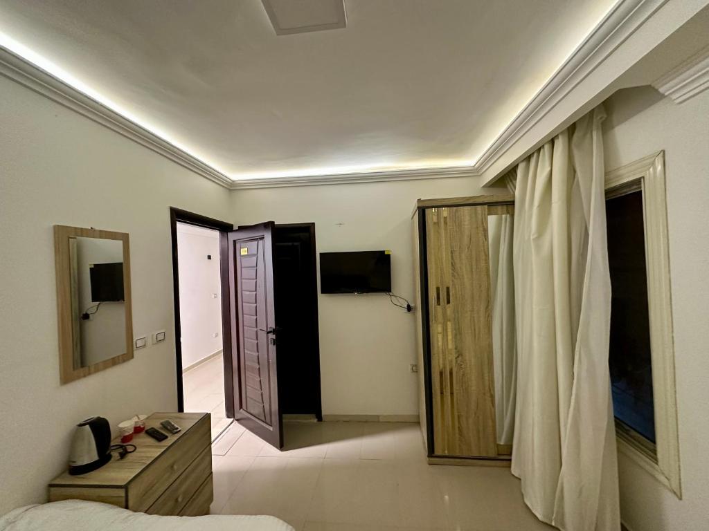 a bedroom with a bed and a room with a door at Pyramids Serenity in Cairo