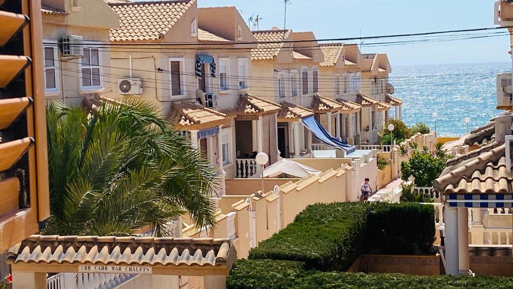 a row of houses on a street with the ocean at Apartment-House La Mata Torrevieja in Torrevieja