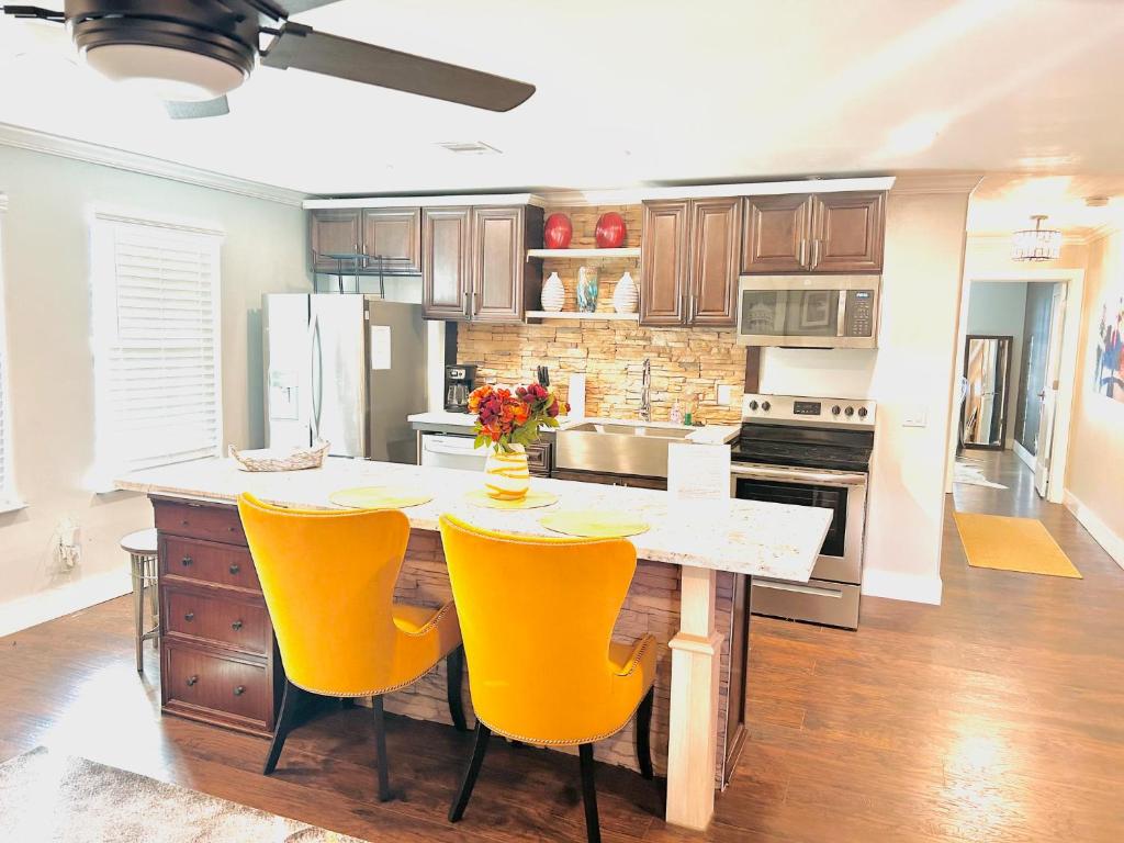 eine Küche mit einem Tisch und gelben Stühlen in der Unterkunft Golden Heart @ Tanglewood in Houston