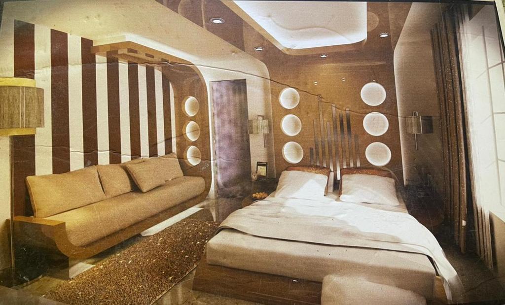 um quarto com uma cama e um sofá em فيلا للإيجار في الشيخ زايد em ‘Ezbet `Abd el-Ḥamîd