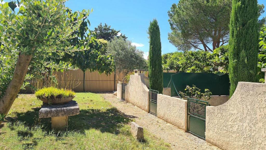 un jardin avec une clôture et un arbre dans l'établissement Au Mont Gaussier, à Saint-Rémy-de-Provence