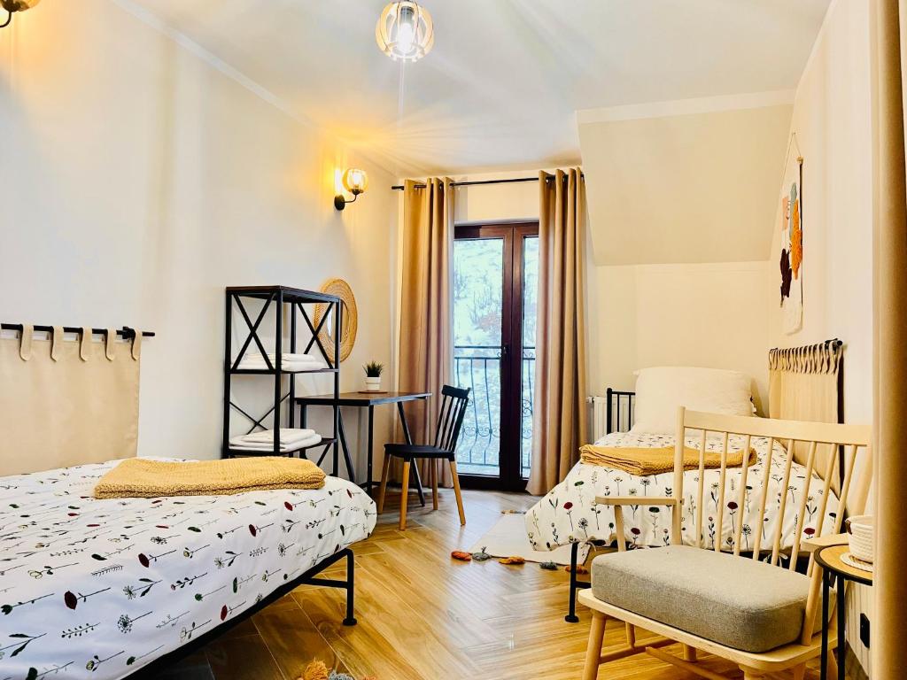GÓRSKA CISZA - Apartamenty في سترونيش لونسكي: غرفة نوم بسريرين وطاولة وكراسي