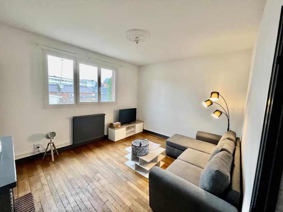 un salon avec un canapé et une télévision dans l'établissement Le Lovely avec parking, à Amiens