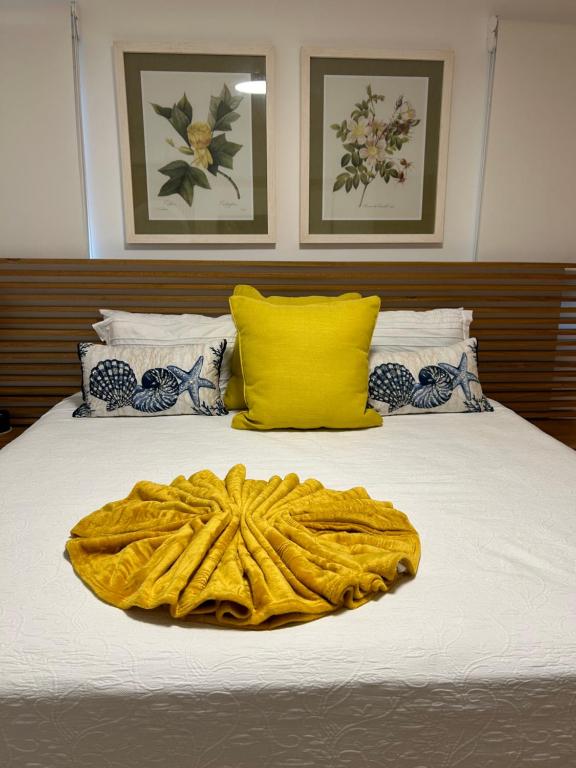 a bed with a yellow blanket on top of it at Casa Coral in San Felipe de Puerto Plata