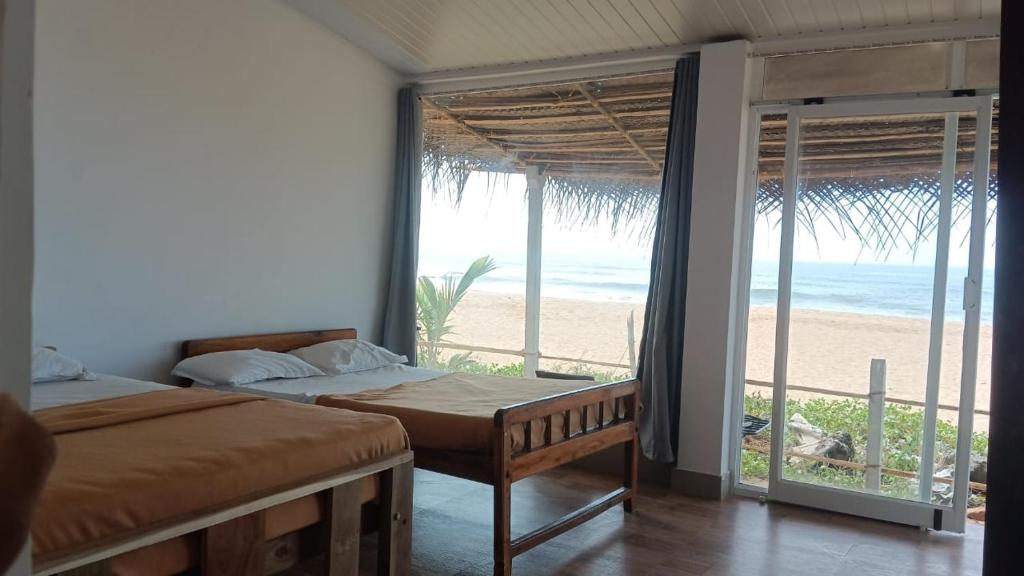 a bedroom with two beds and a view of the beach at The Meraki Beach Resort in Gokarna