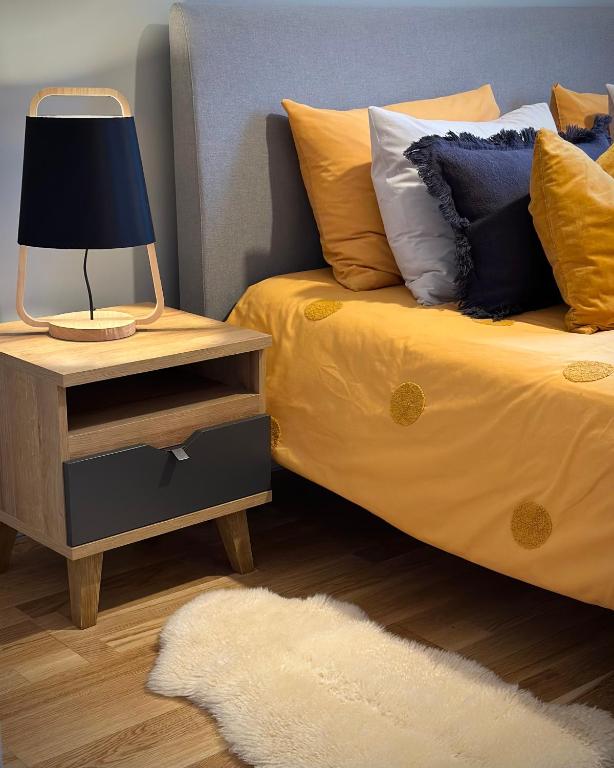 a bed with a night stand with a lamp on it at Riga A new designed cosy family apartment in Riga