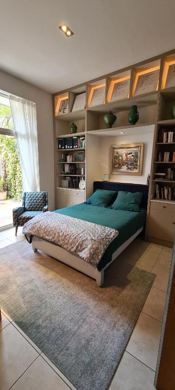 a bedroom with a green bed and a book shelf at Suite indépendante avec 1 chambre et 1 bureau in Montpellier