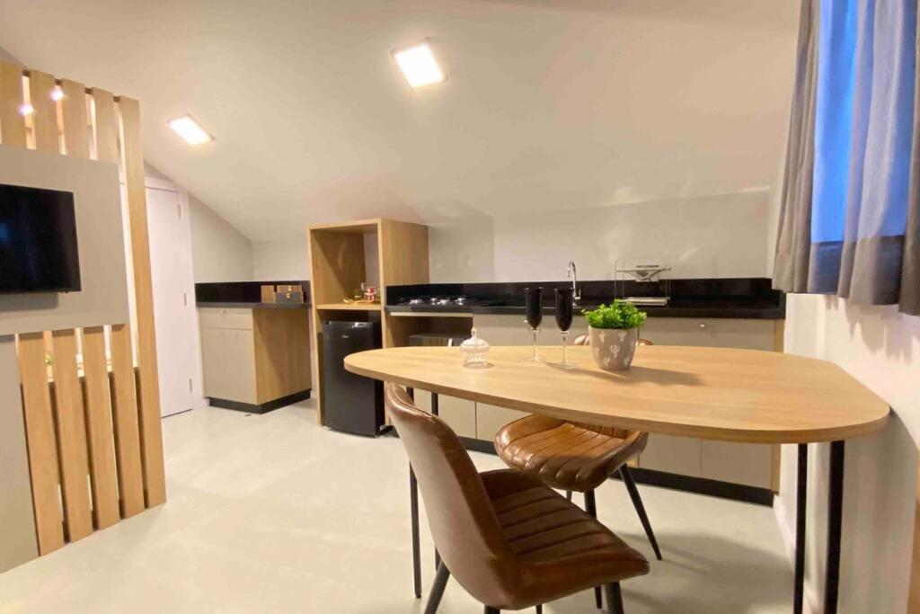 eine Küche mit einem Holztisch und 2 Stühlen in der Unterkunft Loft do Vale in Pomerode