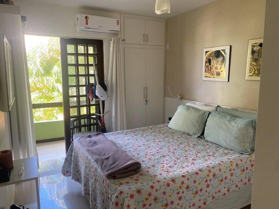 1 dormitorio con 1 cama en una habitación con ventana en Lindo Vilage em Praia do Flamengo!, en Salvador