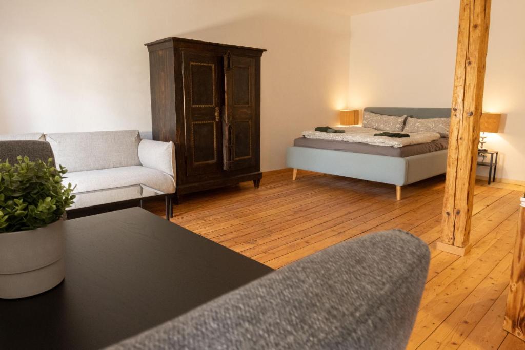 a living room with a bed and a mirror at Loft Apartment mit großer Badewanne B in Mügeln