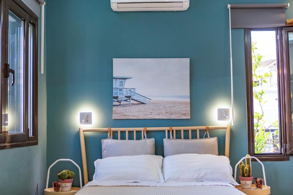 sypialnia z niebieskimi ścianami i łóżkiem z 2 poduszkami w obiekcie Panorama Loft w Chalkidzie