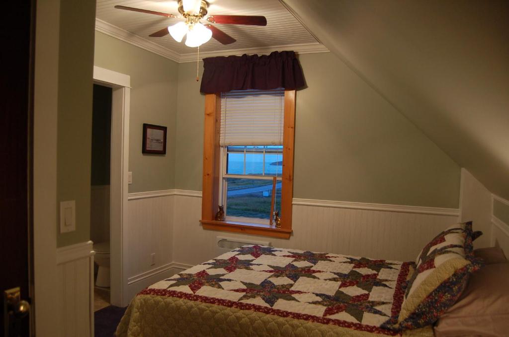 een slaapkamer met een bed en een raam bij The Yellow Sidecar B&B in Cap Le Moine