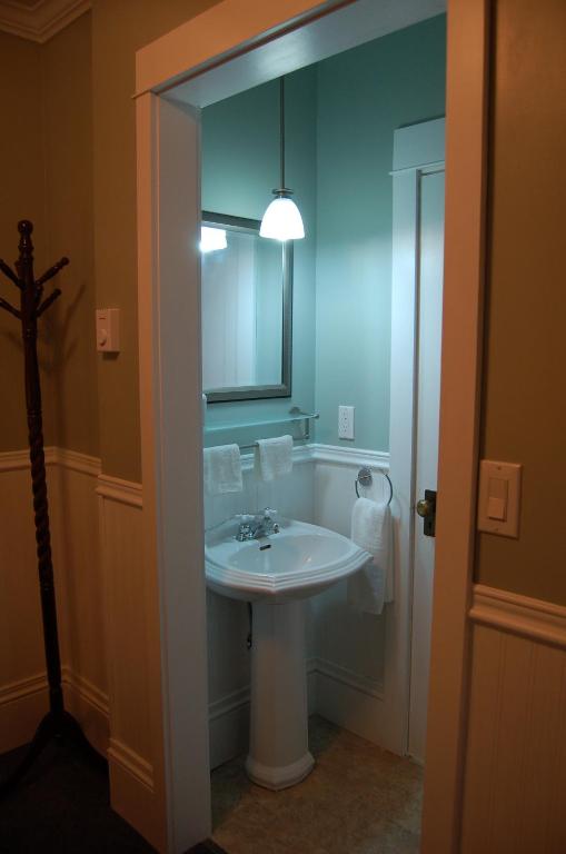 a bathroom with a white sink and a mirror at The Yellow Sidecar B&B in Cap Le Moine