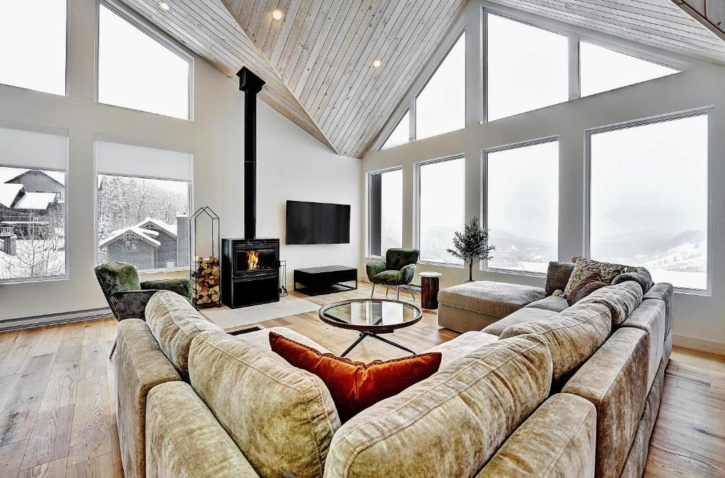 sala de estar grande con sofá grande y ventanas grandes en 32 Chemin Blanc, en Stoneham