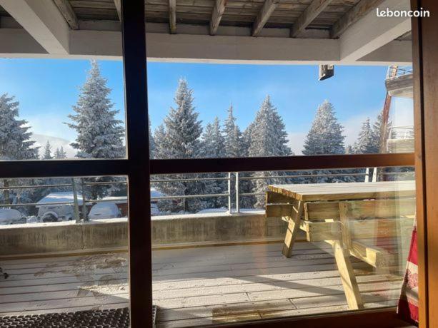 - une vue depuis la fenêtre d'une terrasse avec une table dans l'établissement Appartement tout confort - Chamrousse - pied des pistes, à Chamrousse