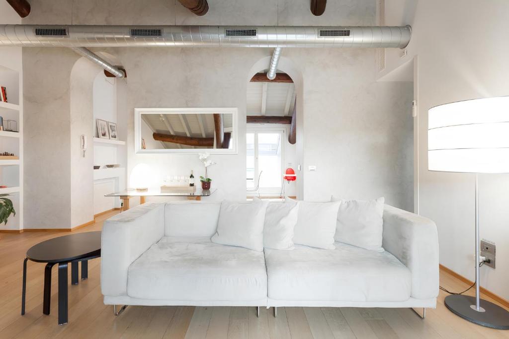 ein Wohnzimmer mit einem weißen Sofa und einem Tisch in der Unterkunft Como Sweet Como in Como