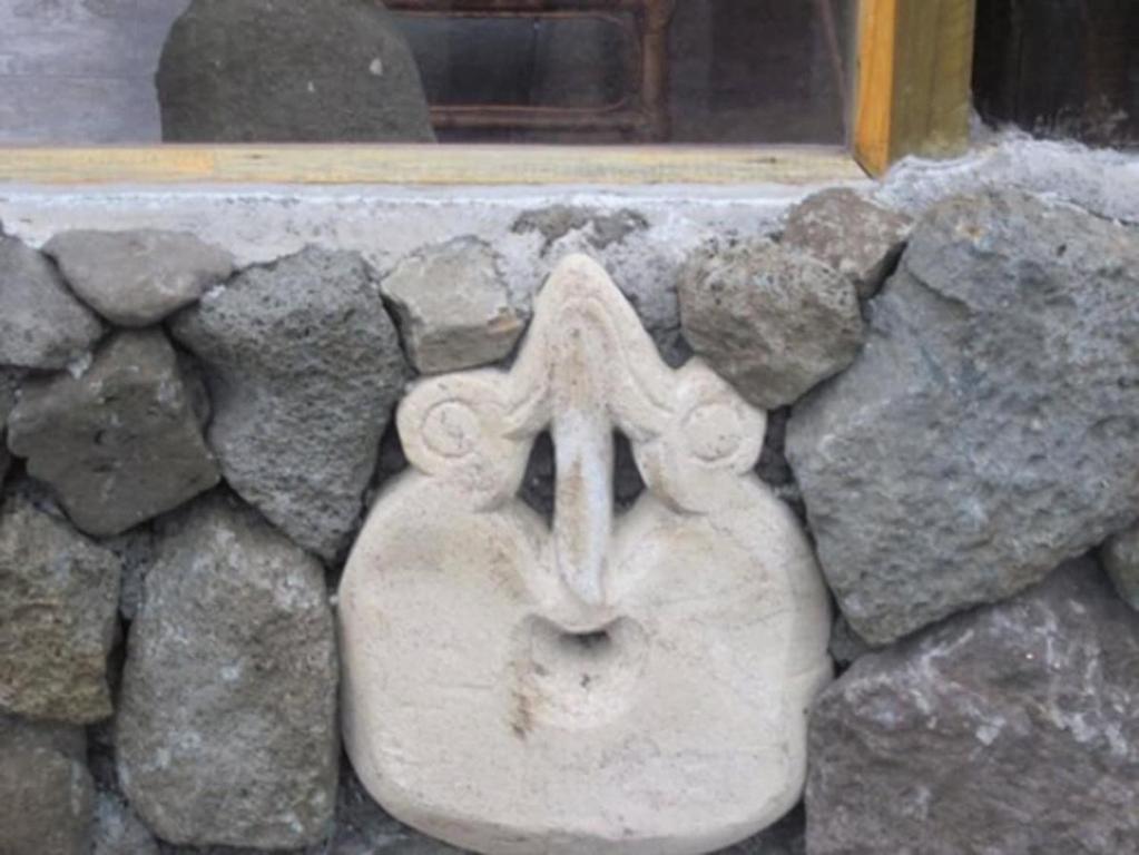 a stone gargoyle on a rock wall at Atavai Hotel Rapa Nui in Hanga Roa