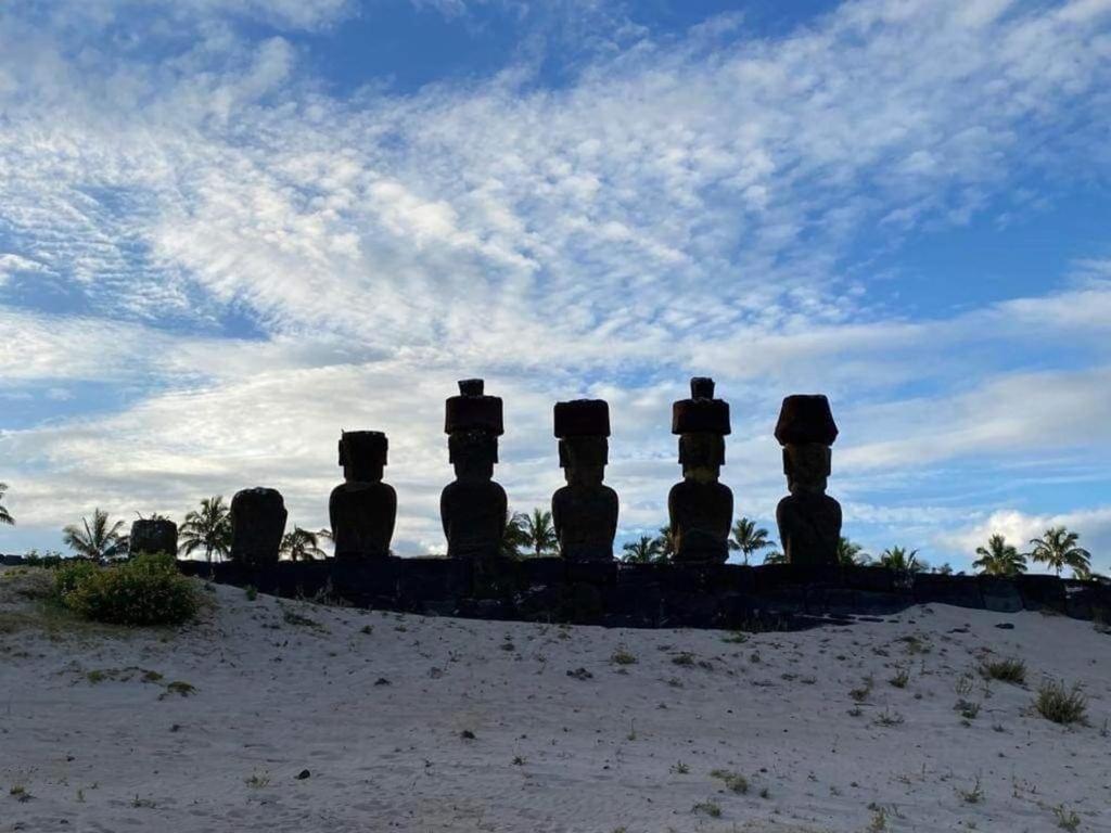 a group of statues sitting on top of a field at Atavai Hotel Rapa Nui in Hanga Roa