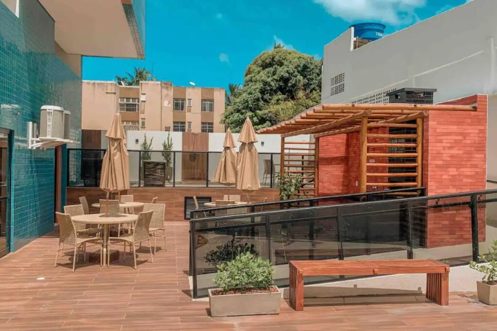 a patio with a table and chairs and umbrellas at Studio a 300m da praia in Maceió