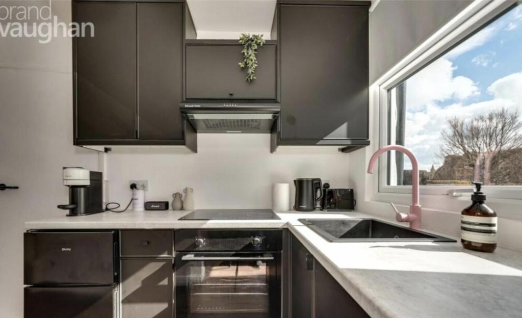 a kitchen with stainless steel appliances and a window at Central Hove Quiet Top Floor Flat with Terrace in Brighton & Hove