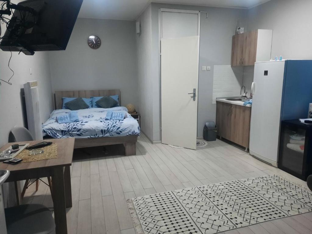1 dormitorio con cama, mesa y cocina en Stan na dan Paracin, en Paraćin
