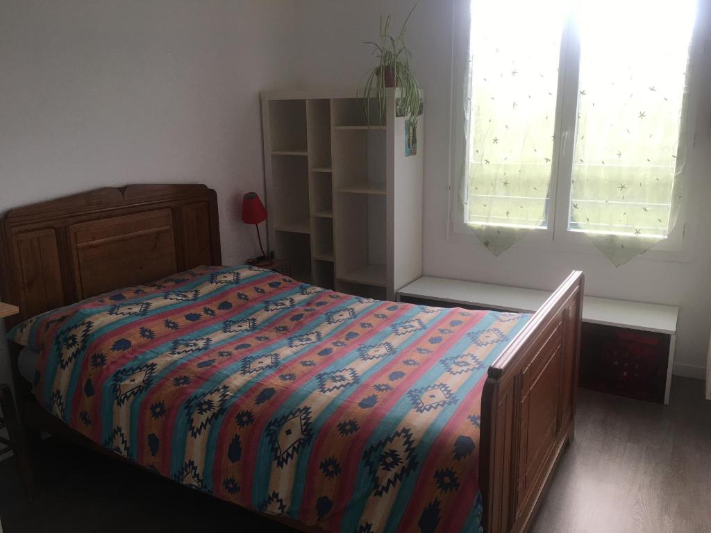 1 dormitorio con 1 cama con un edredón colorido en CHAMBRES, en Trappes