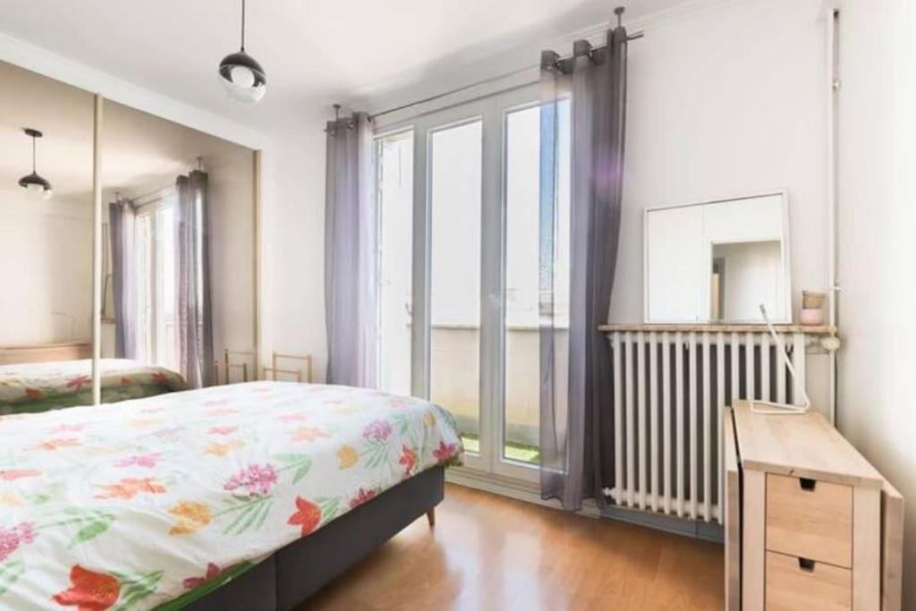 a bedroom with a bed and a large window at Appart Plein Soleil Seine Paris 5ème Jardin Plantes in Paris