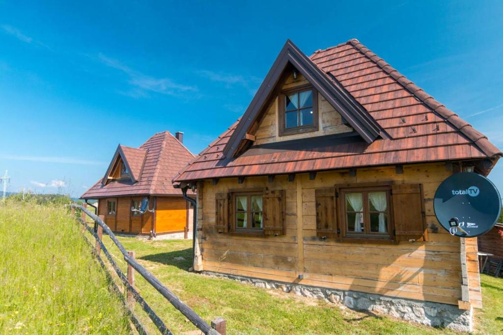 a wooden house with a red roof at Mašine kolibe in Kaludjerske Bare