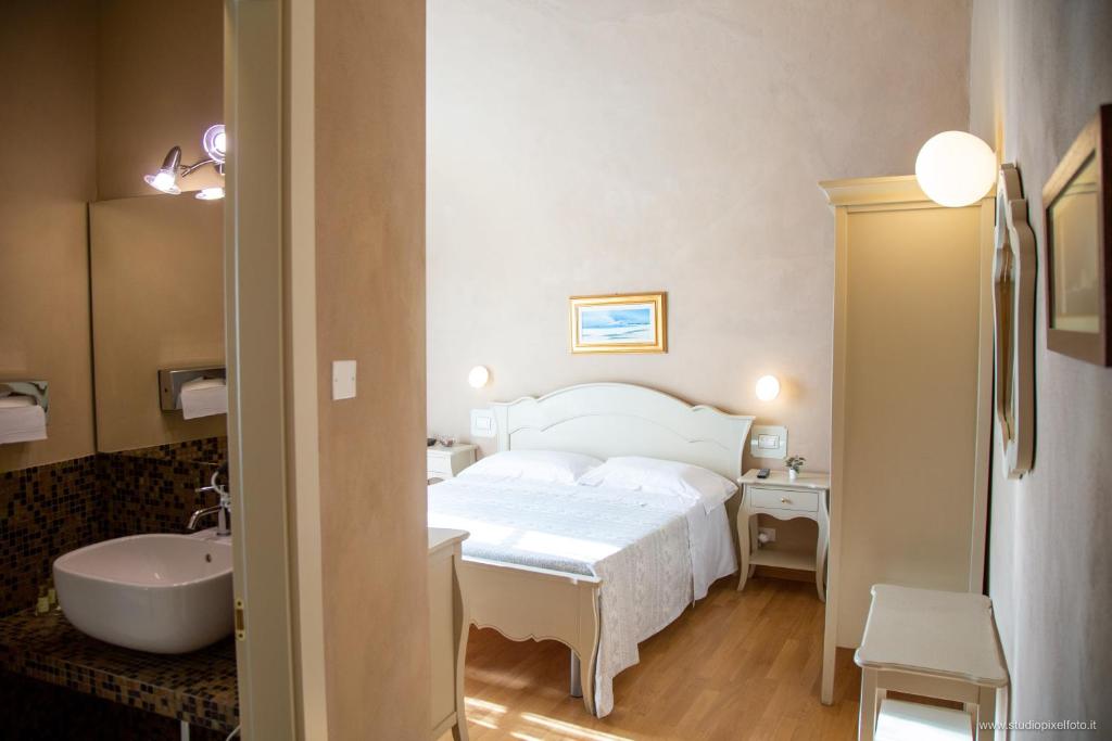ピサにあるResidenza d'Epoca Relais I Miracoliのベッドルーム(ベッド1台、シンク、バスタブ付)