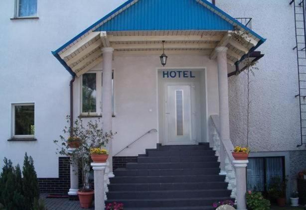 een hotelgebouw met een trap naar de deur bij Usługi Noclegowe i Gastronomiczne dla Ludności Robert Mielcarek in Kobyla Góra