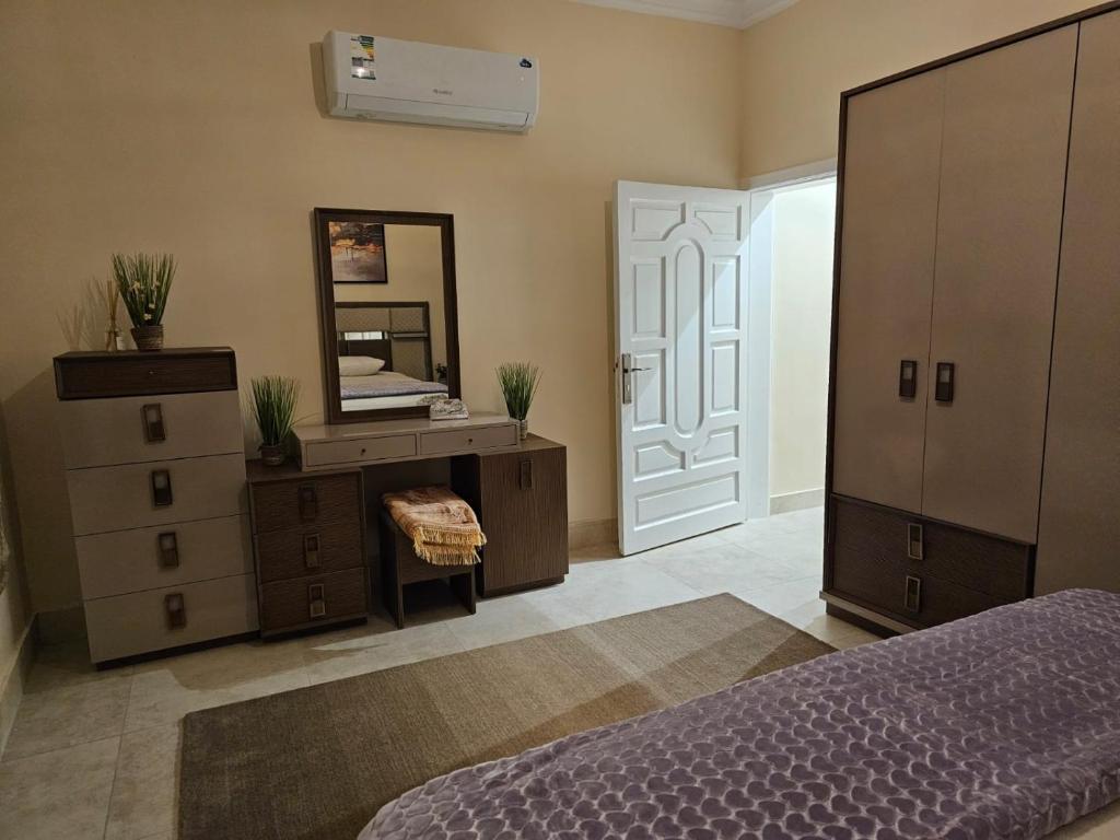 a bedroom with a bed and a dresser and a mirror at شقة جود طيبة الفندقية Jood Taibah Luxury Apartment in Al Madinah