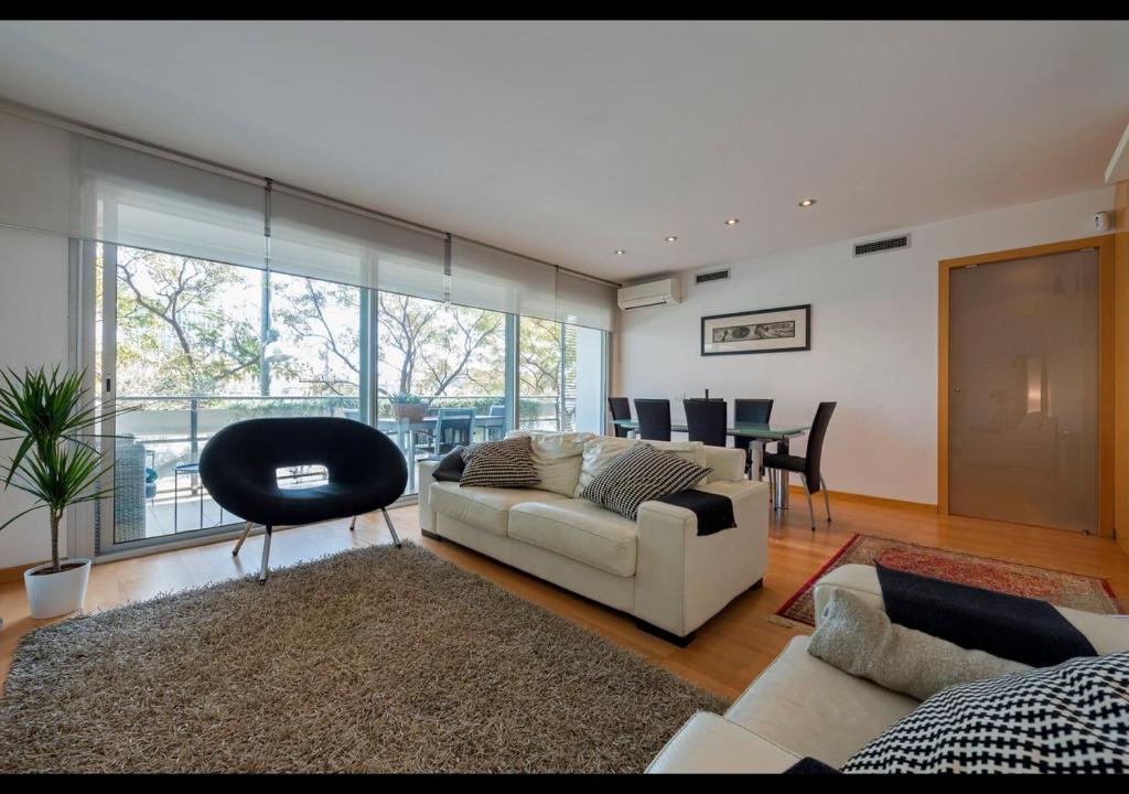 uma sala de estar com um sofá e uma sala de jantar em CCIB Forum Deluxe Apartment em Barcelona